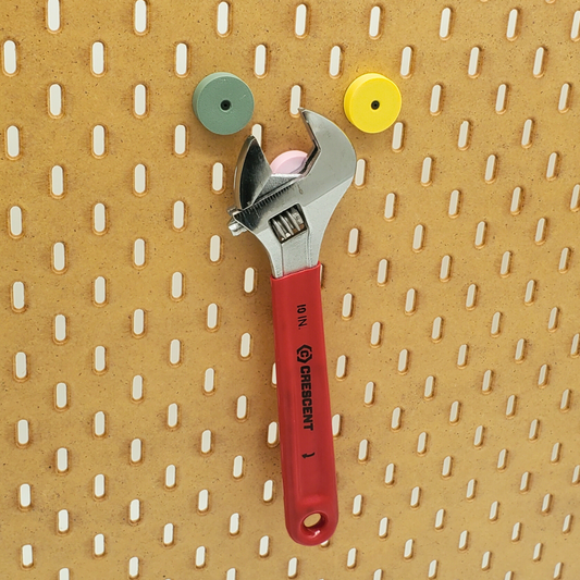 Savannah Yellow, Muted Green magnets on SKADIS pegboard, Light Pink magnet holding heavy adjustable wrench