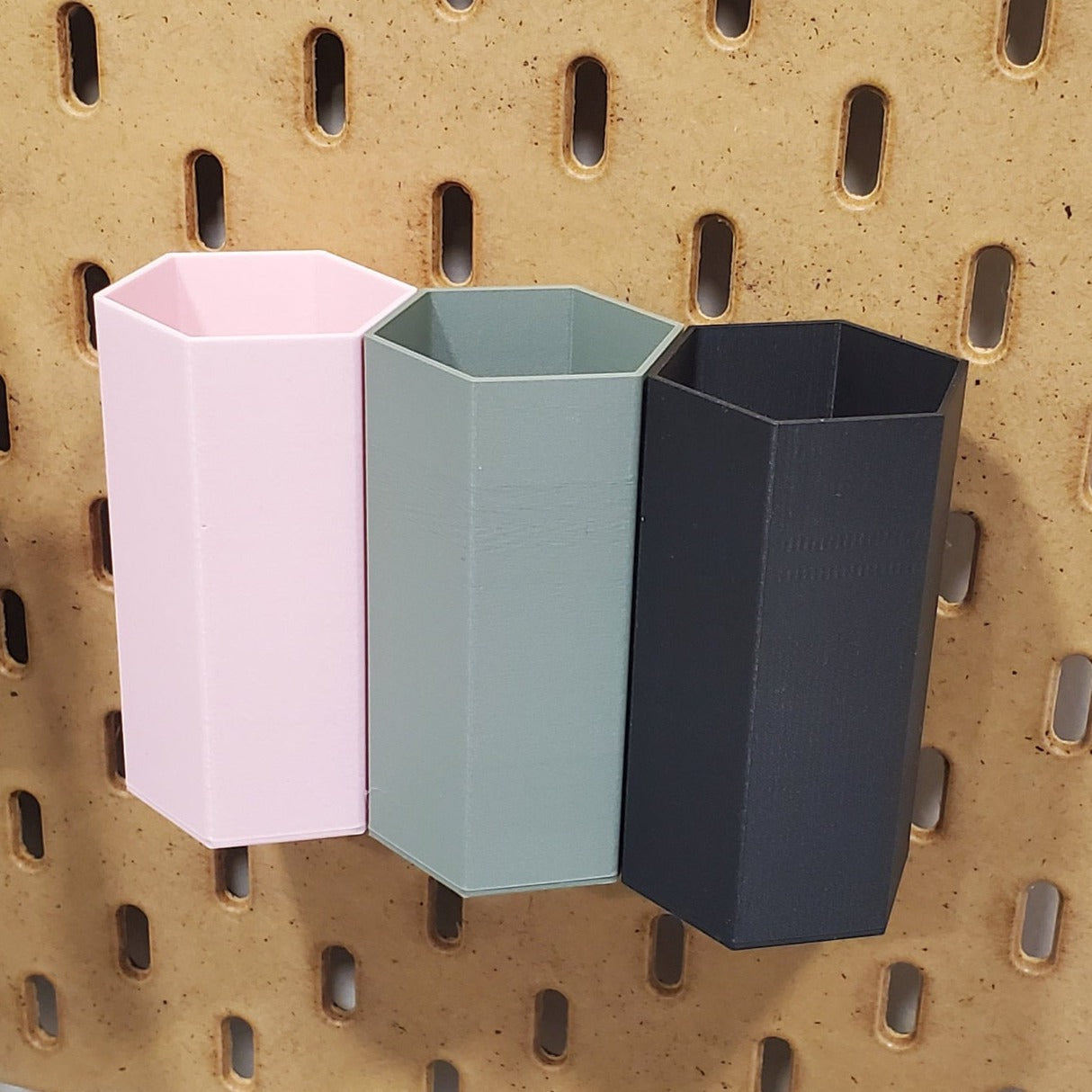 3 Small Hexagonal shaped IKEA Skadis accessories for storing pens, pencils and other items.